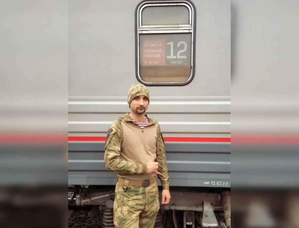 Никита Митченко позирует на фоне поезда «Грозный-Москва» в апреле 2022 года. Источник: личная страница ВКонтакте.