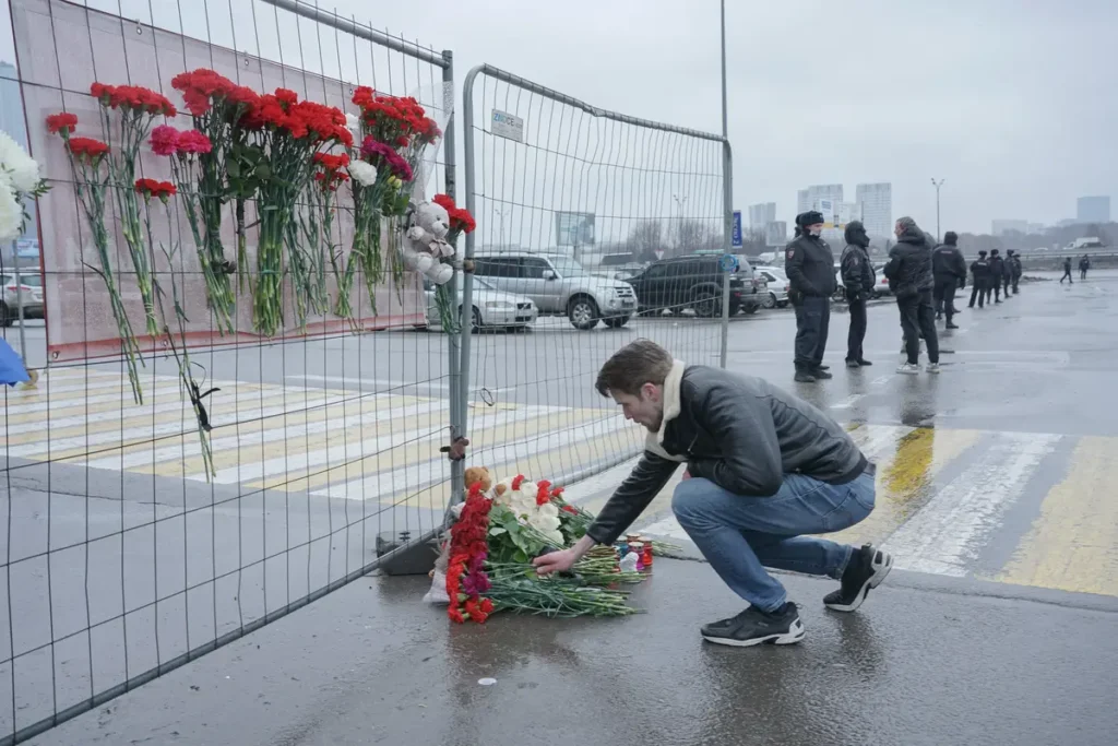 Люди начинают приносить цветы к стихийному мемориалу возле Крокус Сити Молл на следующий день после трагедии. Источник: специальный корреспондент «Вёрстки».