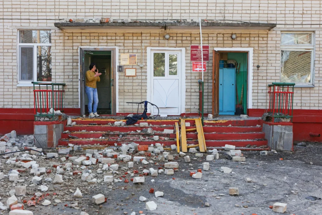 Женщина стоит у входа в здание детского сада, пострадавшее от обстрела в Белгороде, 20 марта 2024 года.