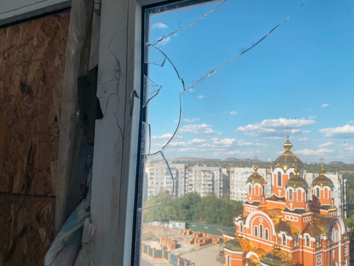 Вид на храм святого великомученика Пантелеимона Целителя из разбитого окна многоквартирного дома в Донецке