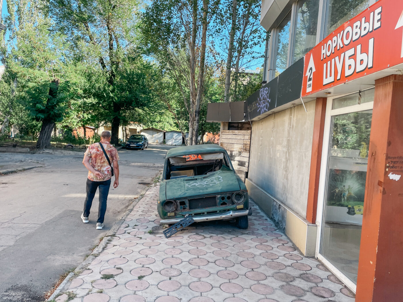 Разбитая машина на улице в Донецке — в городе отчётливо заметны следы войны